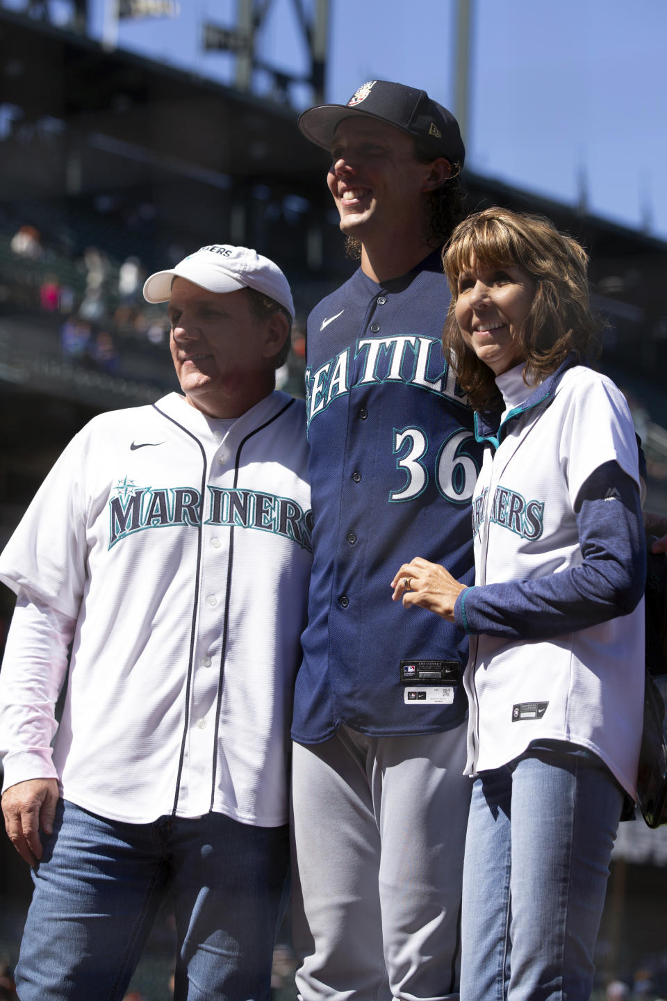 Keith and Noel Gilbert pose for photos with their son, Seattle Mariners starting pitcher Logan Gilbert, after the Mariners' 6-0 victory over the San Francisco Giants in a baseball game Tuesday, July 4, 2023, in San Francisco. (AP Photo/D. Ross Cameron)