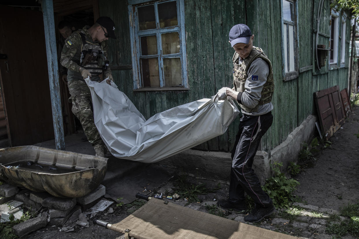 La policía ucraniana saca el cuerpo de un hombre de 60 años de su casa en Lisichansk, Ucrania, el 24 de mayo de 2022. (Finbarr O'Reilly/The New York Times)
