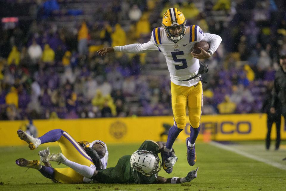 LSU quarterback Jayden Daniels (5) tries to get past UAB cornerback Starling Thomas V (4) during the first half of an NCAA college football game in Baton Rouge, La., Saturday, Nov. 19, 2022. (AP Photo/Matthew Hinton)