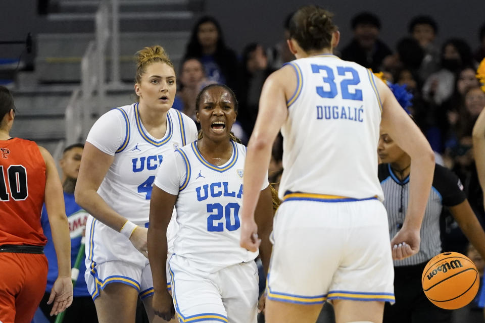 UCLA guard Charisma Osborne (20), reacts with forward Angela Dugalic (32) after drawing an and-one call during the first half of an NCAA college basketball game against Princeton, Friday, Nov. 17, 2023, in Los Angeles. (AP Photo/Ryan Sun)