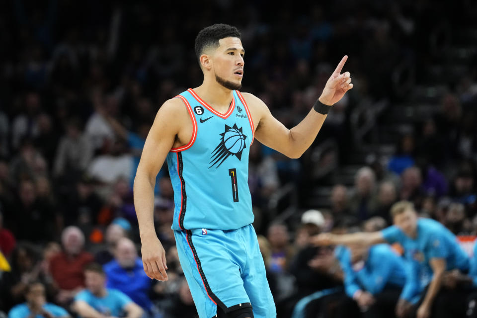 Phoenix Suns guard Devin Booker (1) motions after a basket against the Golden State Warriors during the second half of an NBA basketball game, Wednesday, Nov. 16, 2022, in Phoenix. (AP Photo/Matt York)