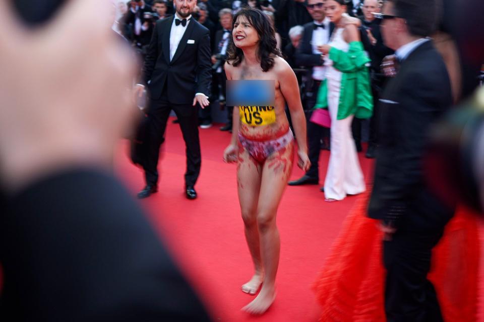 (EDITORS NOTE: Image contains nudity.) A protester makes her way onto the red carpet during the 