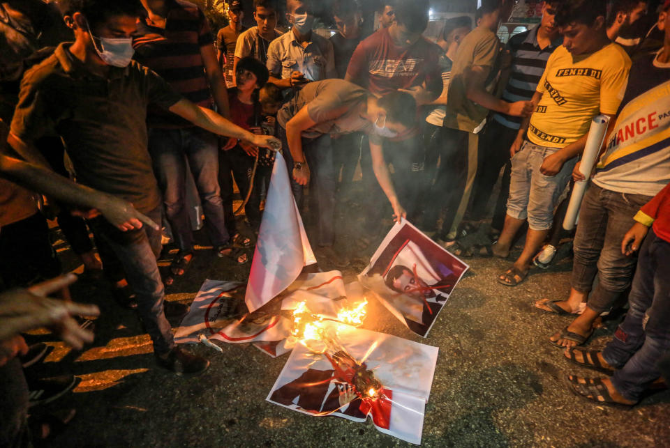 GAZA, PALESTINE - 2020/10/25: Protesters burning placards with portraits of the French president during the demonstration. Palestinians in the city of Rafah protest against the publishing of cartoons as Prophet Muhammad in a French newspaper and the statement of French President Emmanuel Macron. (Photo by Yousef Masoud/SOPA Images/LightRocket via Getty Images)