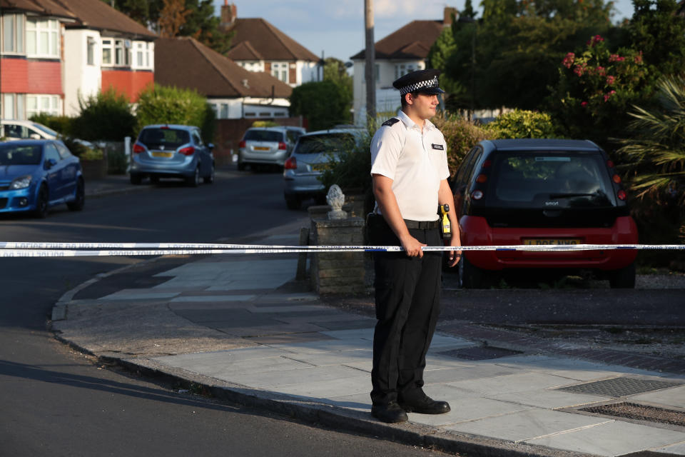 A police officer at a cordon near to Redfern Avenue in Whitton, south-west London, where two people, a man in his 60s and a woman in her 70s, were found stabbed to death.