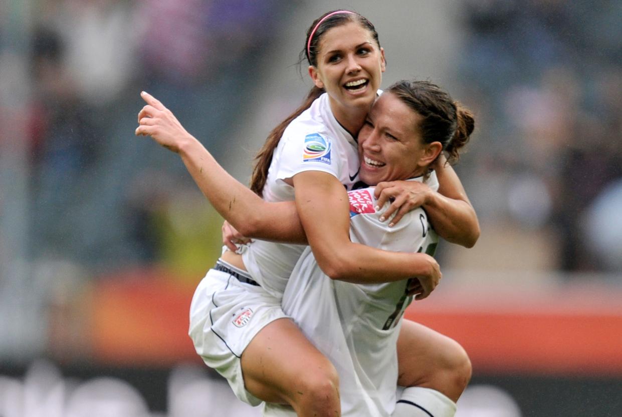 Alex Morgan is carried by United States' Lauren Cheney in celebration after she scored their side's 3rd goal during the semifinal match between France and the United States at the World Cup in Moenchengladbach, Germany, Wednesday, July 13, 2011.