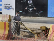 A road crew works on a road outside the Formula One corniche circuit, in Jiddah, Saudi Arabia, Sunday, Nov. 21, 2021. Next month's F1 race will be the first time Saudi Arabia hosts the premier sporting event, though the kingdom has hosted the lesser known Formula-E race in past years in an effort to raise the country's profile as a tourist destination. (AP Photo/Amr Nabil)