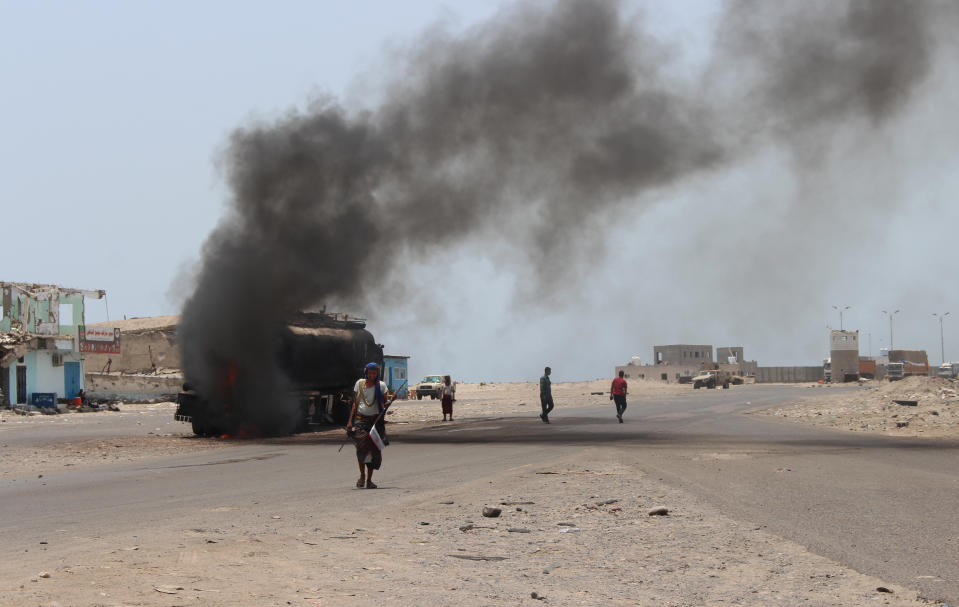 People inspect an oil tanker truck set ablaze during recent clashes between Yemeni southern separatists and government forces near Aden, Yemen, Friday, Aug. 30, 2019. (AP Photo/Wail al-Qubaty)