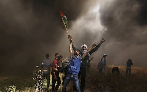Palestinian demonstrators shout during clashes with Israeli troops  - Credit: Reuters