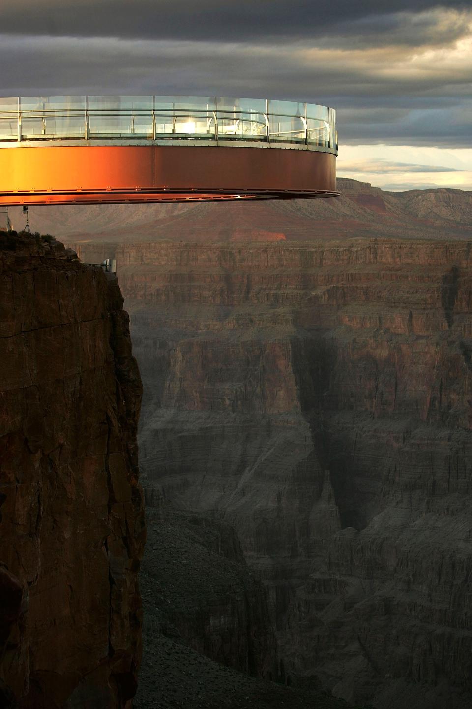 In this March 2007 file photo, the sun set on the Skywalk, the cantilevered glass walkway extending from the western Grand Canyon's rim over the Colorado River, on the Hualapai Reservation. The construction of the Skywalk on Hualapai Indian tribal land, 90 miles downstream from Grand Canyon National Park, stirred controversy with some tribal elders and environmentalists who condemned it as a desecration of a sacred American landscape.