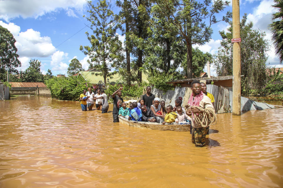 FILE - A family uses a boat after fleeing floodwaters that wreaked havoc in the Githurai area of Nairobi, Kenya, April 24, 2024. (AP Photo/Patrick Ngugi, File)