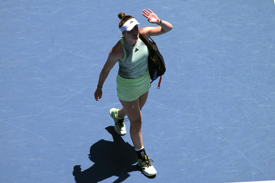 Elina Svitolina of Ukraine waves as she walks from the court after retiring from her fourth round match against Linda Noskova of the Czech Republic at the Australian Open tennis championships at Melbourne Park, Melbourne, Australia, Monday, Jan. 22, 2024. (AP Photo/Alessandra Tarantino)