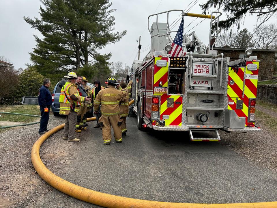 Somerset volunteer fire department personnel gather next to the fire truck as they start to tear down their equipment at the Clark Street fire scene.