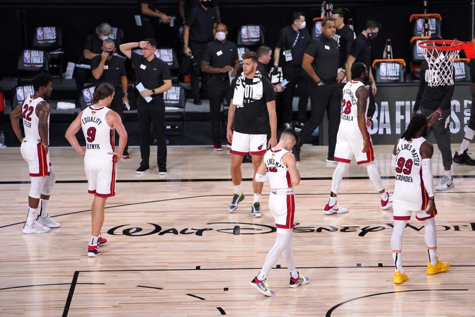 The Miami Heat's Jimmy Butler (22), Kelly Olynyk (9), Meyers Leonard, center rear, Tyler Herro, center front, Andre Iguodala (28) and Jae Crowder (99) walk off the court after their 124-114 loss to the Miami Heat in Game 2 of basketball's NBA Finals, Friday, Oct. 2, 2020, in Lake Buena Vista, Fla. (AP Photo/Mark J. Terrill)