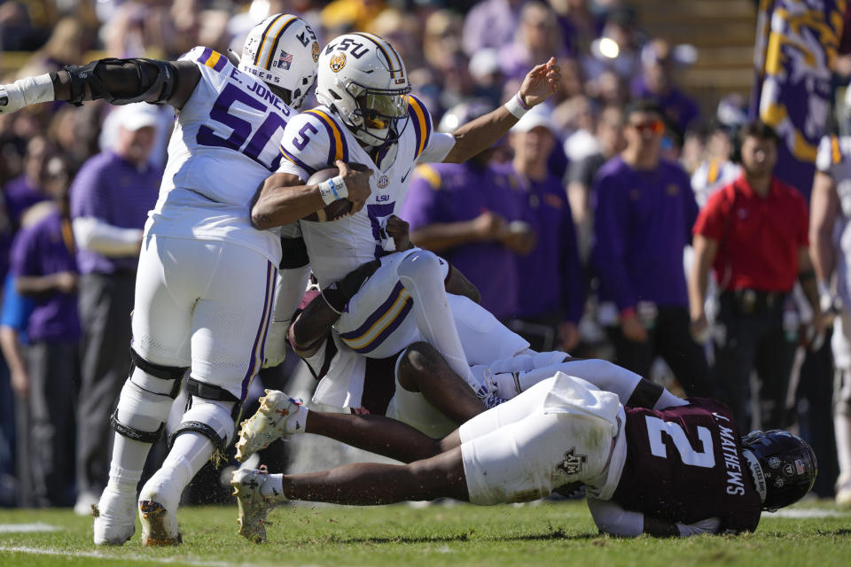 LSU quarterback Jayden Daniels (5) is sacked by Texas A&M linebacker Edgerrin Cooper and defensive back Jacoby Mathews (2) in the first half of an NCAA college football game in Baton Rouge, La., Saturday, Nov. 25, 2023. (AP Photo/Gerald Herbert)