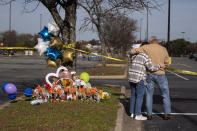 Debbie, left, and Chet Barnett place flowers at a memorial outside of the Chesapeake, Va., Walmart on Thursday, Nov. 24, 2022. Andre Bing, a Walmart manager, opened fire on fellow employees in the break room of the Virginia store, killing six people in the country’s second high-profile mass shooting in four days, police and witnesses said Wednesday. (Billy Schuerman/The Virginian-Pilot via AP)