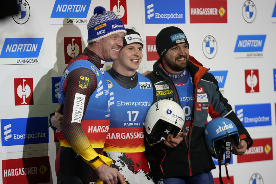 First-place finisher Italy's Dominik Fischnaller, center, shares the podium with second-place finisher Germany's Felix Loch, left, and third-place finisher David Gleirscher, right, of Austria, following the men's singles at a World Cup luge event Friday, Dec. 16, 2022, in Park City, Utah. (AP Photo/Rick Bowmer)