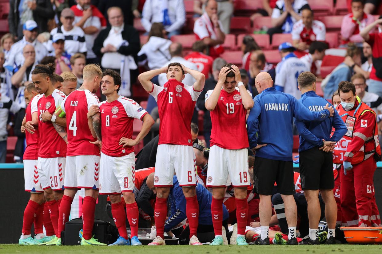 TOPSHOT - Denmark's players react as paramedics attend to Denmark's midfielder Christian Eriksen after he collapsed on the pitch during the UEFA EURO 2020 Group B football match between Denmark and Finland at the Parken Stadium in Copenhagen on June 12, 2021. (Photo by Friedemann Vogel / POOL / AFP) (Photo by FRIEDEMANN VOGEL/POOL/AFP via Getty Images)