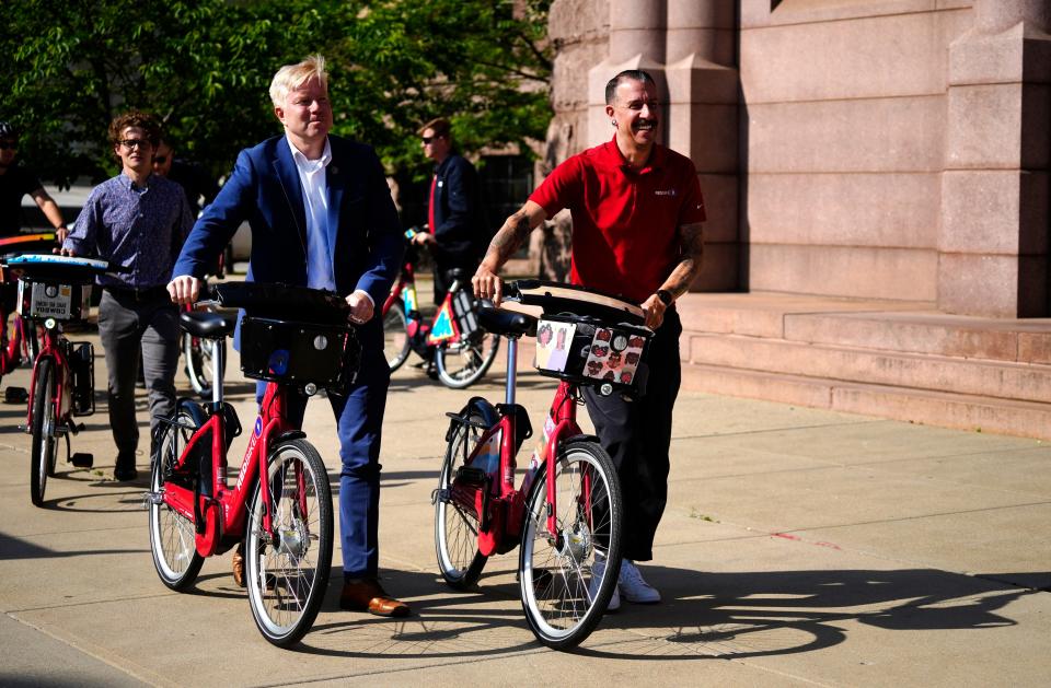 Cincinnati City Council member Mark Jeffreys, left and Red Bike Executive Director Doug McClintock, walk their Red Bikes back to City Hall.