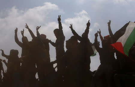 Palestinian demonstrators gesture during clashes with Israeli troops at a protest at the Israel-Gaza border, April 27, 2018. REUTERS/Mohammed Salem