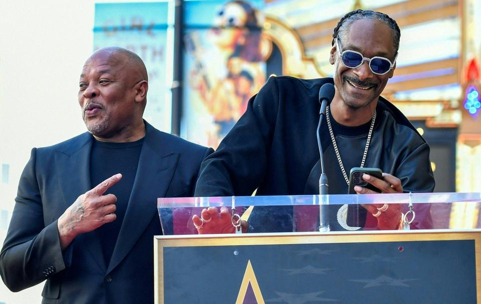 Dr. Dre, left, and Snoop Dogg appear at Dr. Dre's Hollywood Walk of Fame ceremony in Hollywood on March 19. The two rappers are now the title sponsors of the Arizona Bowl college football game.