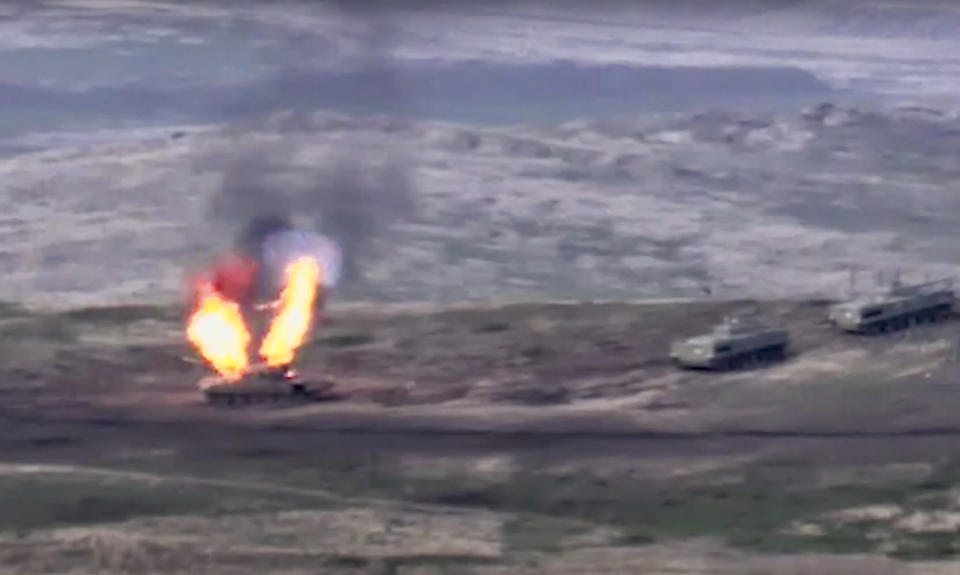 In this image taken from a footage released by Armenian Defense Ministry on Sunday, Sept. 27, 2020, Armenian forces destroy Azerbaijani tank at the contact line of the self-proclaimed Republic of Nagorno-Karabakh, Azerbaijan. Fighting between Armenia and Azerbaijan has broken out around the separatist region of Nagorno-Karabakh and the Armenian Defense Ministry says two Azerbaijani helicopters have been shot down. Ministry spokeswoman Shushan Stepanyan also said Armenian forces hit three Azerbaijani tanks. (Armenian Defense Ministry via AP)