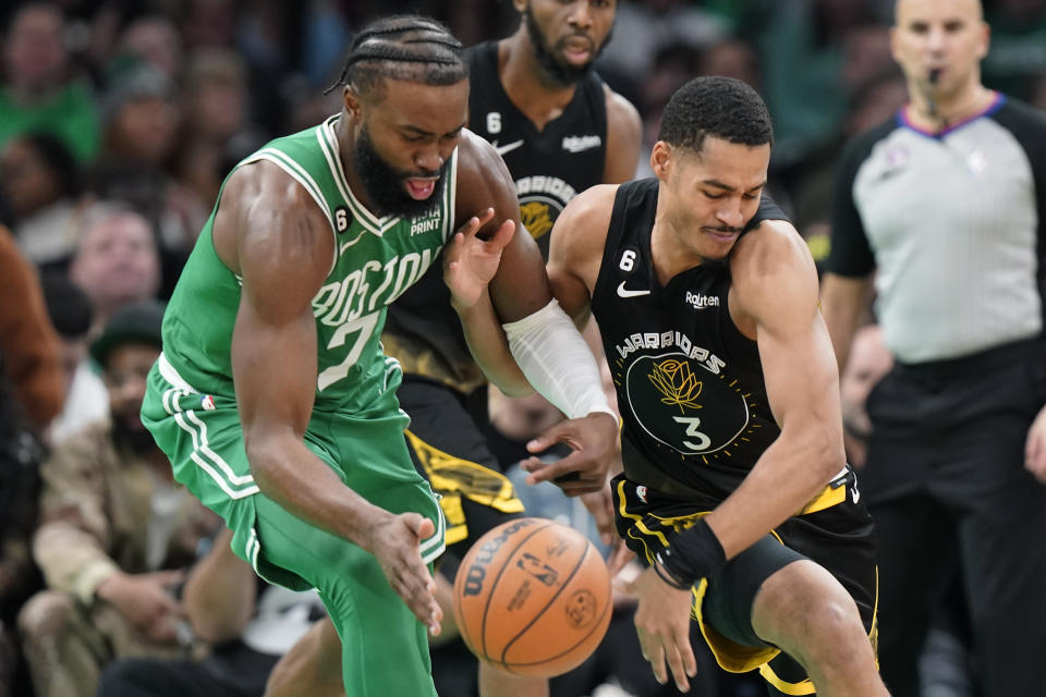 Boston Celtics guard Jaylen Brown (7) and Golden State Warriors guard Jordan Poole (3) vie for control of the ball in the first half of an NBA basketball game, Thursday, Jan. 19, 2023, in Boston. (AP Photo/Steven Senne)