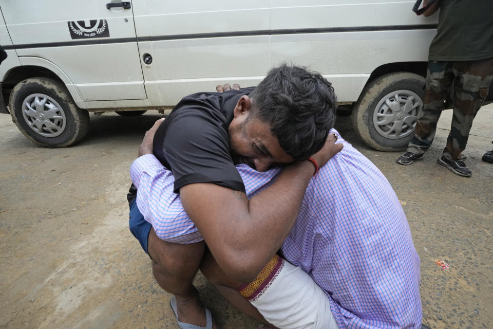 A man weeps while hugging the father-in-law of his 37-year-old sister Ruby, victim of a stampede, outside Hathras district hospital, Uttar Pradesh, India, Wednesday, July 3, 2024. Thousands of people at a religious gathering rushed to leave a makeshift tent, setting off a stampede Tuesday that killed more than hundred people and injured scores. (AP Photo/Rajesh Kumar Singh)