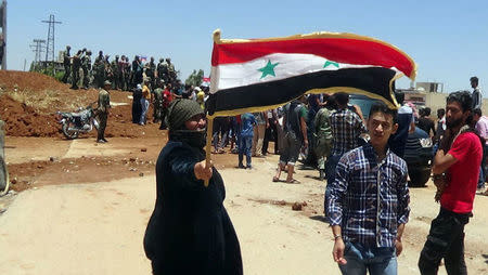 Residents celebrate the army's arrival in the formerly rebel-held town of Ibta, northeast of Deraa city, Syria in this handout released on June 29, 2018. SANA/Handout via REUTERS