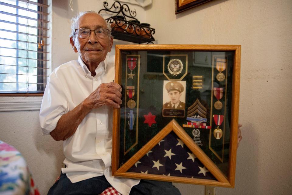 Simon Mendoza, who turns 100 on Friday, Oct. 28, poses with the medals he received as an Army infantryman in World War II.