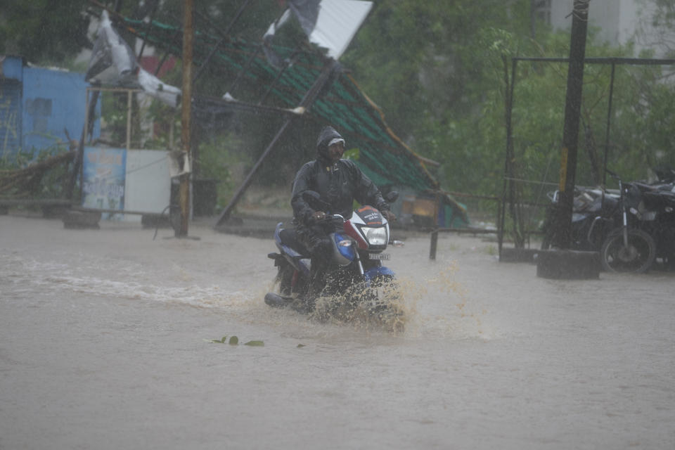 A motorcyclist rides through a flooded street following heavy winds and incessant rains after landfall of cyclone Biparjoy at Mandvi in Kutch district of Western Indian state of Gujarat, Friday, June 16, 2023. Cyclone Biparjoy knocked out power and threw shipping containers into the sea in western India on Friday before aiming its lashing winds and rain at part of Pakistan that suffered devastating floods last year. (AP Photo/Ajit Solanki)