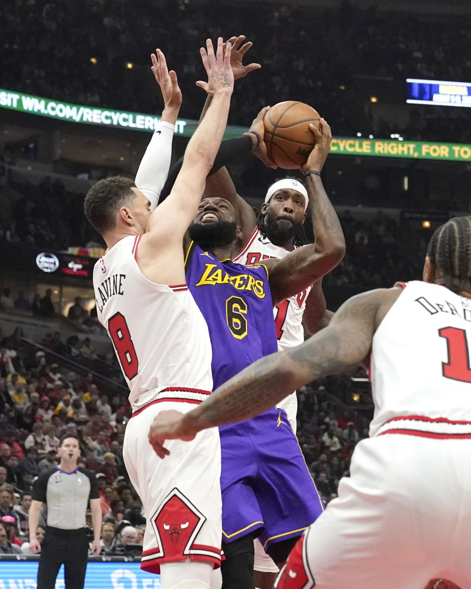 Los Angeles Lakers' LeBron James (6) shoots under pressure from Chicago Bulls' Zach LaVine (8) and Patrick Beverley during the first half of an NBA basketball game, Wednesday, March 29, 2023, in Chicago. (AP Photo/Charles Rex Arbogast)