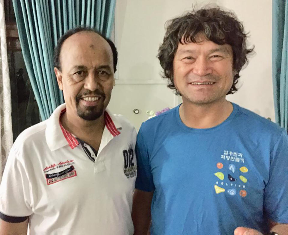 In this undated photo released by the Pakistan Alpine Club on Tuesday, July 20, 2021, shows club's secretary Karrar Haidri, left, and the now missing Korean climber Kim Hong Bin posing for a photograph, in Islamabad, Pakistan. The famous fingerless South Korean climber Kim Hong Bin fell into a crevasse and went missing after scaling the world's 14th one of the highest peaks in northern Pakistan and a search mission is being planned to trace him, a Pakistani mountaineering official said Tuesday. (Pakistan Alpine Club via AP)