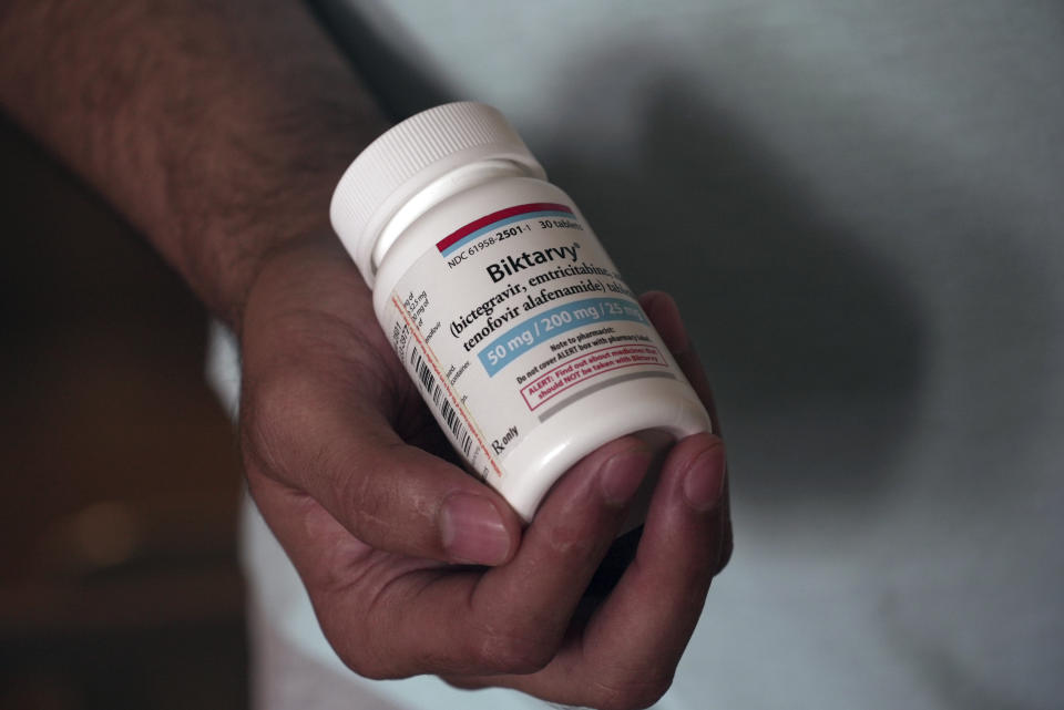 Fernando Hermida holds a bottle of Biktarvy, his HIV medication, in Charlotte, N.C., on May 27, 2024. Hermida received a $1,275 bill earlier this year for the medication, one of the reasons he decided to move to find more affordable treatment. (AP Photo/Laura Bargfeld)