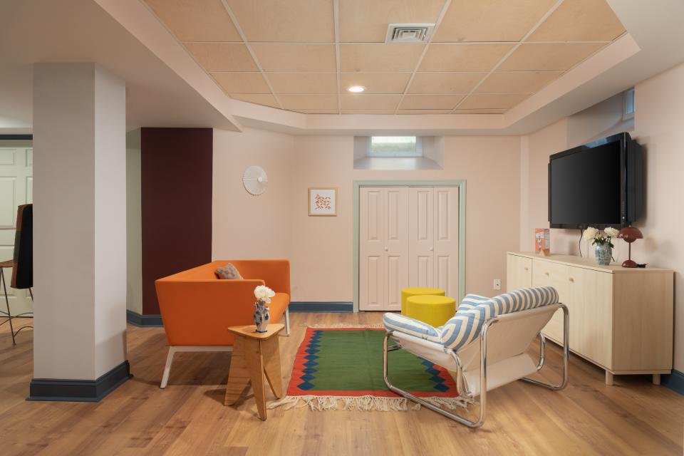 Color and decor choices that help the eye distinguish from one living space to another gave this wide open basement some organization.