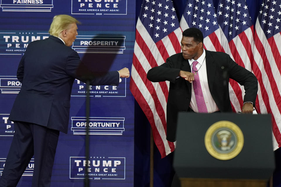 FILE - In this Sept. 25, 2020, file photo, President Donald Trump elbow bumps with Herschel Walker during a campaign rally in Atlanta. Walker appears to have a coveted political profile for a potential Senate candidate in Georgia. (AP Photo/John Bazemore, File)