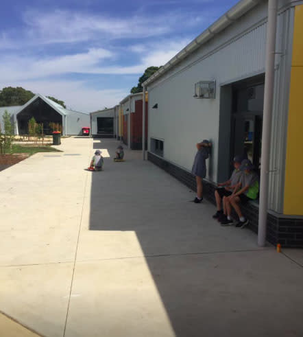 Children can be seen using the shade of buildings to cool down. Source: Facebook/ Ashley Park Primary School