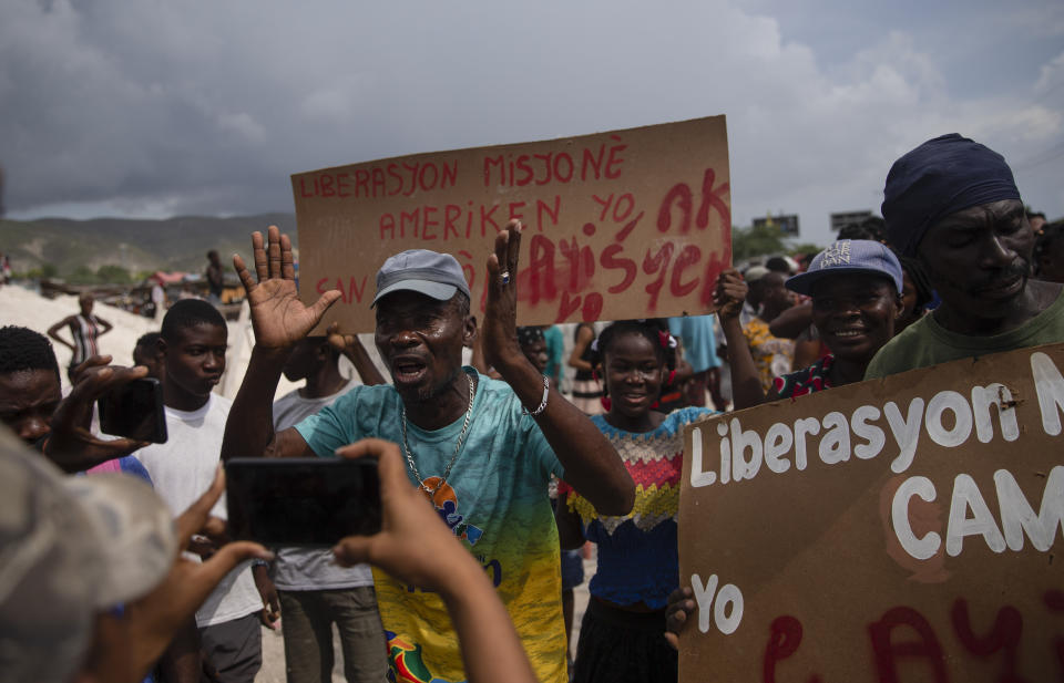 People protest for the release of kidnapped missionaries near the missionaries' headquarters in Titanyen, north of Port-au-Prince, Haiti, Tuesday, Oct. 19, 2021. A group of 17 U.S. missionaries including children was kidnapped by a gang in Haiti on Saturday, Oct. 16, according to a voice message sent to various religious missions by an organization with direct knowledge of the incident. (AP Photo/Joseph Odelyn)