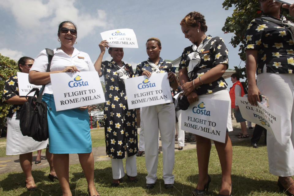 Hostesses wait for passengers of the Costa Allegra cruise ship to arrive in Victoria, Seychelles Island, Thursday, March 1, 2012. The disabled cruise ship arrived in port in the island nation of the Seychelles on Thursday morning after three days at sea without power. (AP Photo/Gregorio Borgia)