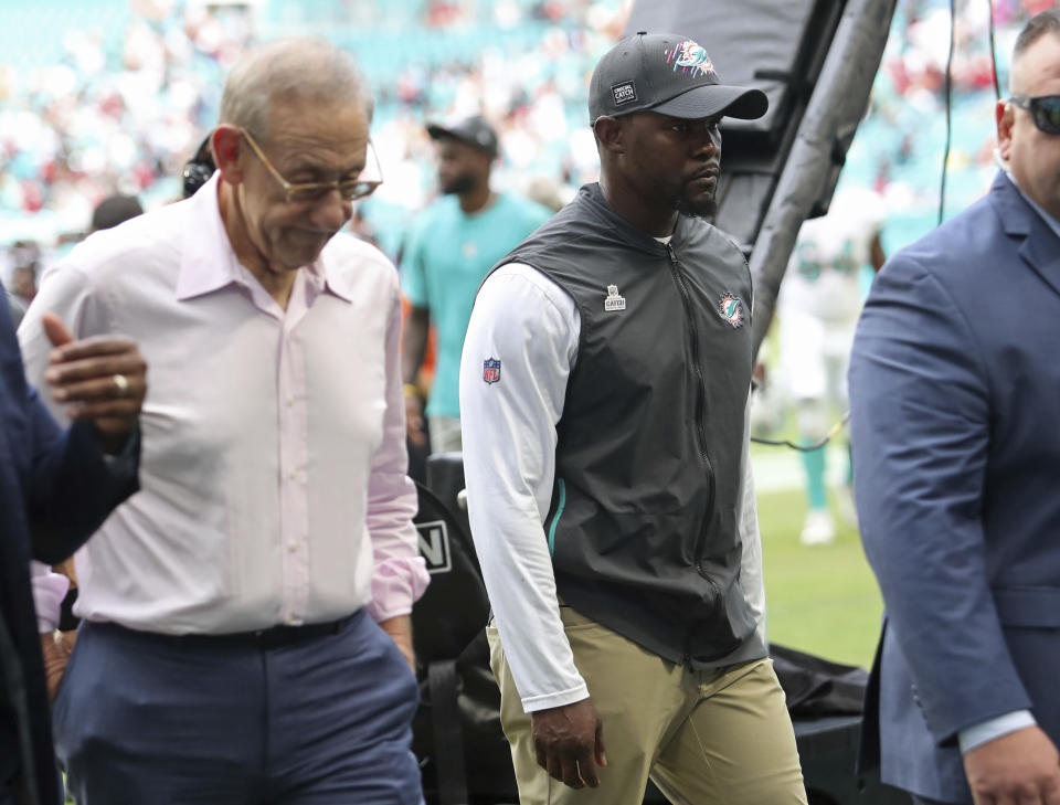 FILE - Miami Dolphins owner Stephen Ross, left, walks off the field next to coach Brian Flores after the team's loss to the Atlanta Falcons in an NFL football game Oct. 24, 2021, in Miami Gardens, Fla. Fired Dolphins coach Flores sued the NFL and three teams Tuesday, Feb. 1, over alleged racist hiring practices for coaches and general managers, saying the league remains “rife with racism” even as it publicly condemns it. According to the lawsuit, Ross told Flores he would pay him $100,000 for every loss during the coach’s first season because he wanted the club to “tank” so it could get the draft’s top pick. Messages left with the Dolphins seeking comment were not immediately returned. (John McCall/South Florida Sun-Sentinel via AP, File)