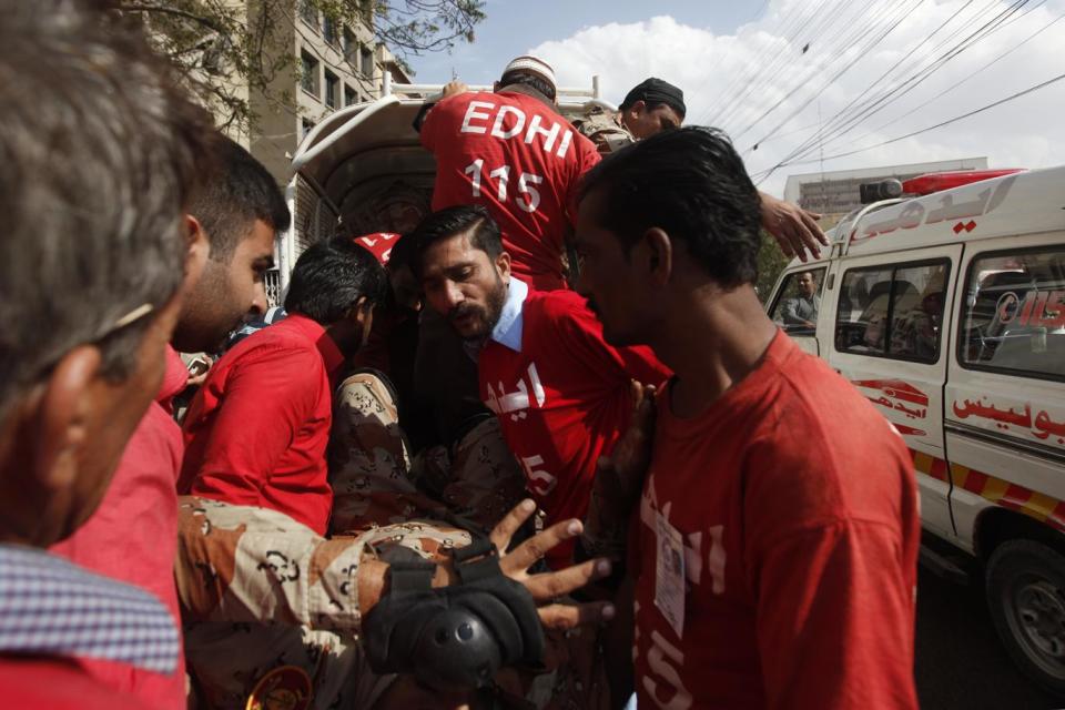 Safdar (centre) transports an injured paramilitary soldier who slipped from his bike (Akhtar Soomro/Reuters)