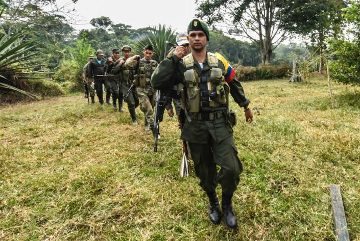 Revolutionary Armed Forces of Colombia members walk towards a camp in the Magdalena Medio region, Antioquia department, Colombia (AFP Photo/Luis Acosta)