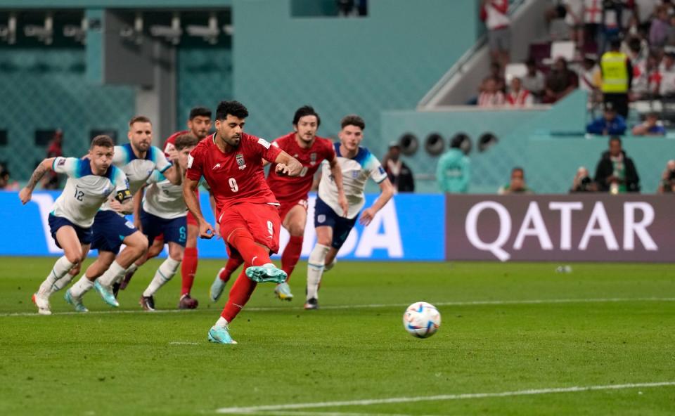 Iran's Mehdi Taremi scores his side's second goal from penalty during the World Cup group B football match between England and Iran at the Khalifa International Stadium in Doha, Qatar, Monday, Nov. 21, 2022. (AP Photo/Frank Augstein)