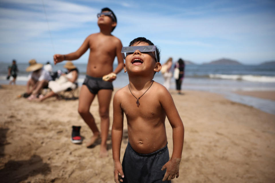 A kid watches the eclipse from the beach on April 08, 2024 in Mazatlan, Mexico.