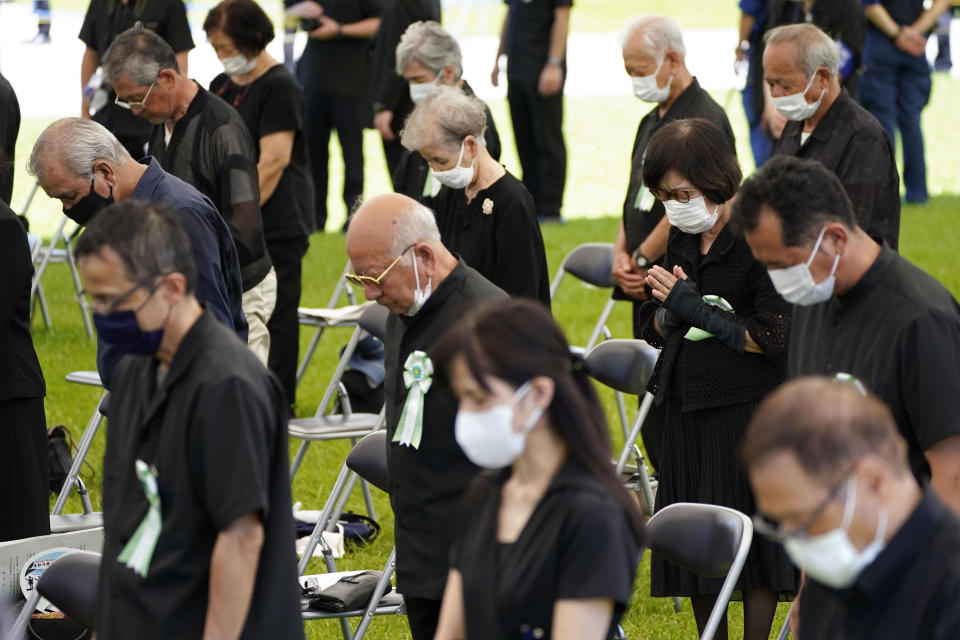 Participants offer a silent prayer at the Peace Memorial Park in Itoman, Okinawa, southern Japan Thursday, June 23, 2022. Japan marked the Battle of Okinawa, one of the bloodiest battles of World War II fought on the southern Japanese island, which ended 77 years ago, Thursday. (Kyodo News via AP)