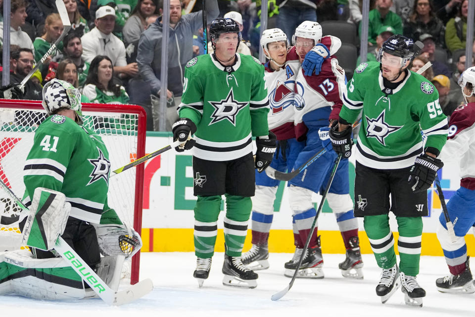 Colorado Avalanche center Nathan MacKinnon, center, celebrates with teammate Valeri Nichushkin (13) after scoring a goal on Dallas Stars goaltender Scott Wedgewood (41) during the first period of an NHL hockey game, Thursday, Jan. 4, 2024 in Dallas. Stars' Ryan Suter, second from left, and Matt Duchene (95) look on. (AP Photo/Julio Cortez)