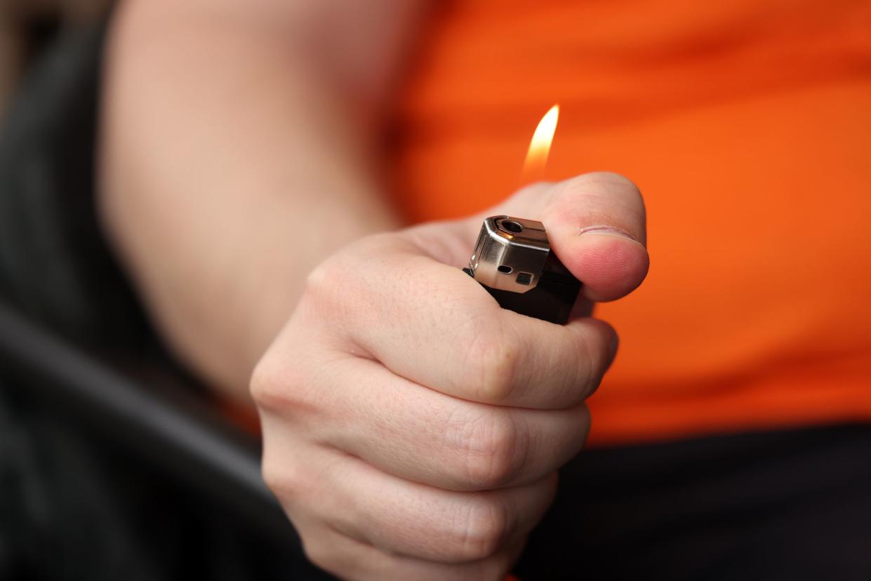 Male hand burning lighter