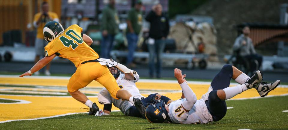 Brian Booms of Flat Rock stretches for a touchdown against Airport defenders Colin Nowak and Cooper Nye (14). Flat Rock won 33-21.