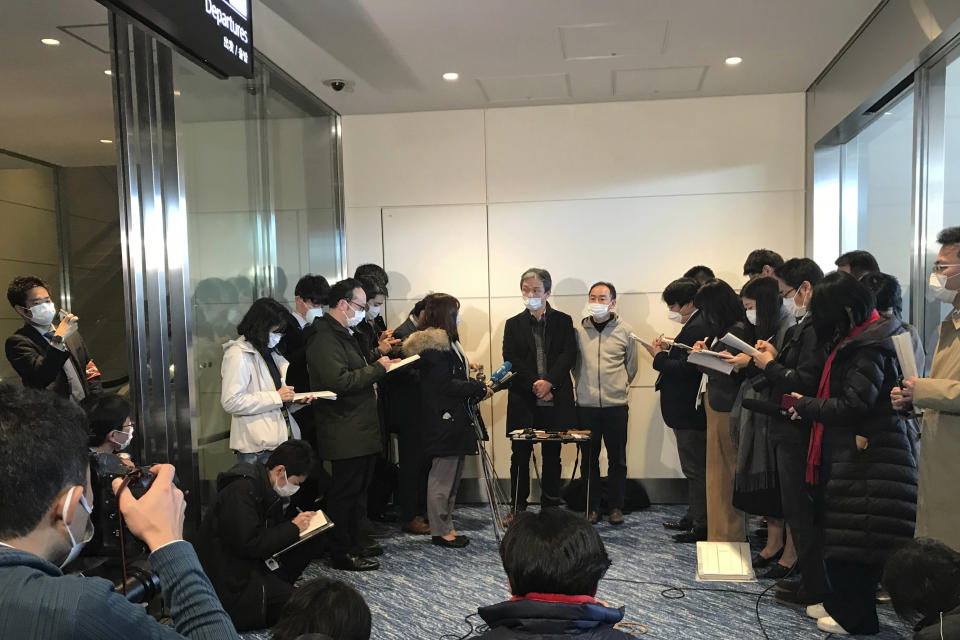 Takeo Aoyama, center left, an employee at Nippon Steel Corp.’s subsidiary in Wuhan, China, and Takayuki Kato, center right, an employee at an information and communications technology company Intec, speak to journalists, all wearing protective face masks, after returning home by a Japanese chartered plane at Haneda international airport in Tokyo Wednesday, Jan. 29, 2020. Japan on Wednesday began evacuating their citizens from the Chinese city hardest-hit by an outbreak of a new virus. Aoyama said more than 400 Japanese people wishing to return to Japan are in Wuhan. (AP Photo/Haruka Nuga)