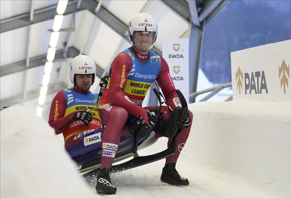 Andris Sics and Juris Sics of Latvia react after they placed second at the Luge World Cup men doubles race in Sigulda, Latvia, Saturday, Jan. 8, 2022. (AP Photo/Roman Koksarov)