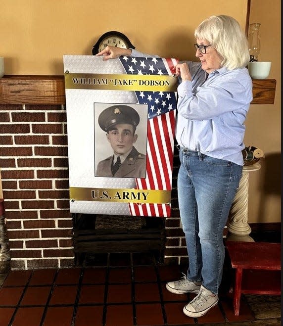 Maryjane Mitchell with a banner honoring her father, William "Jake" Dobson, that will be hung this Memorial Day weekend in Warsaw along with 40 others to honor late veterans.